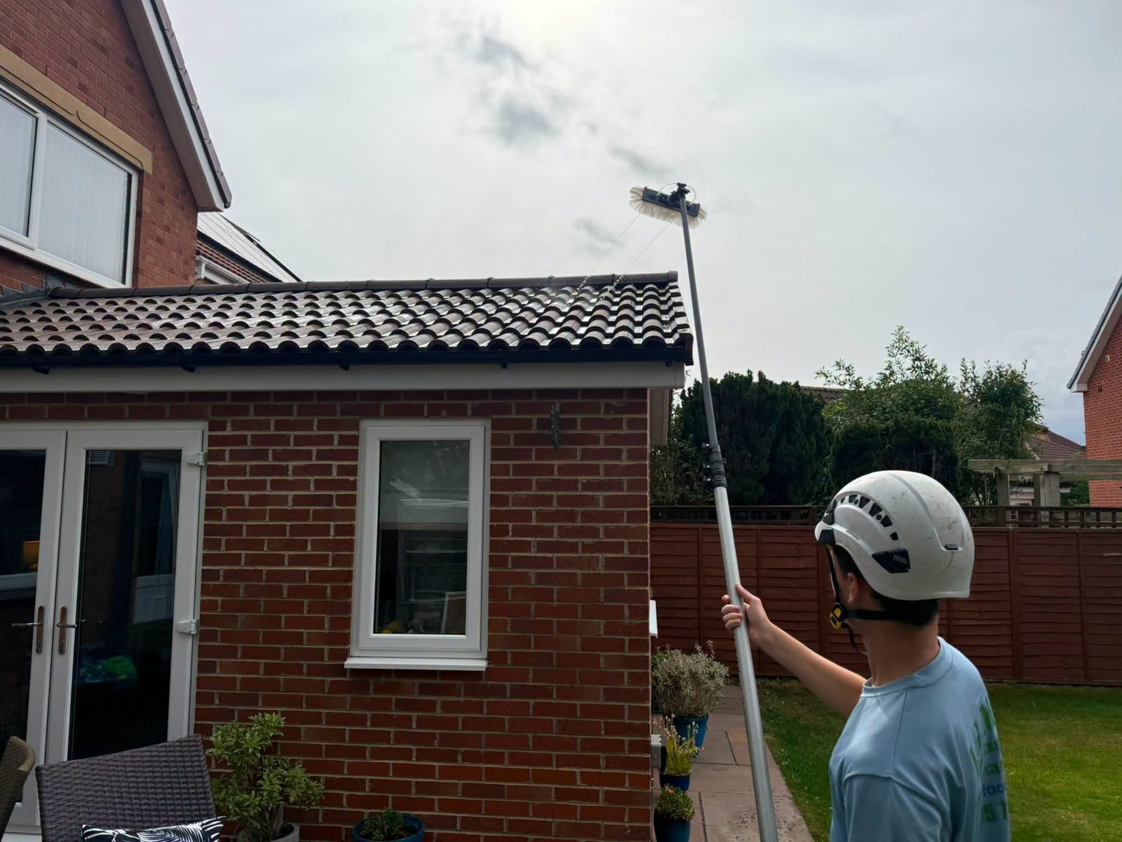 IGM operative using a water-fed pole to clean an extension roof in Teesside