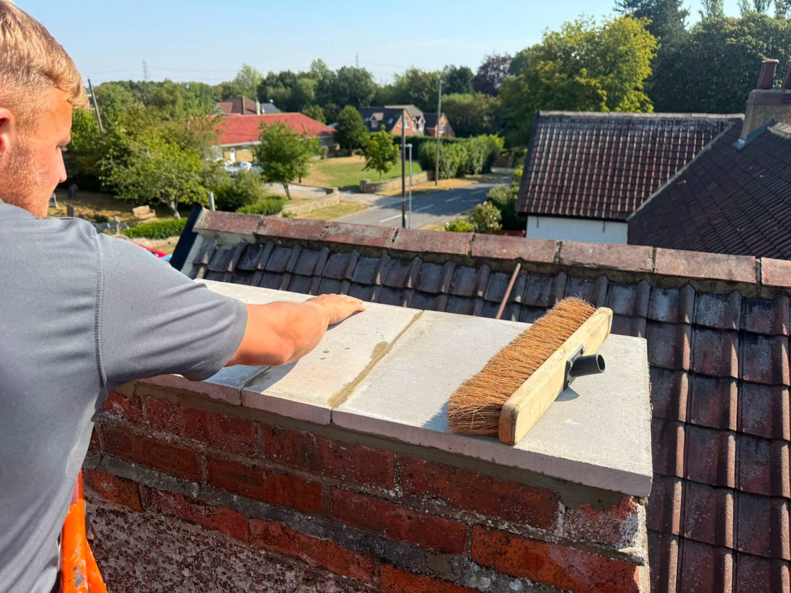 IGM operative brushing down a chimney stack from the cherry picker in Teesside